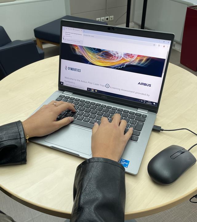 hands on a compputer to star the Symbiotics onkline assessment