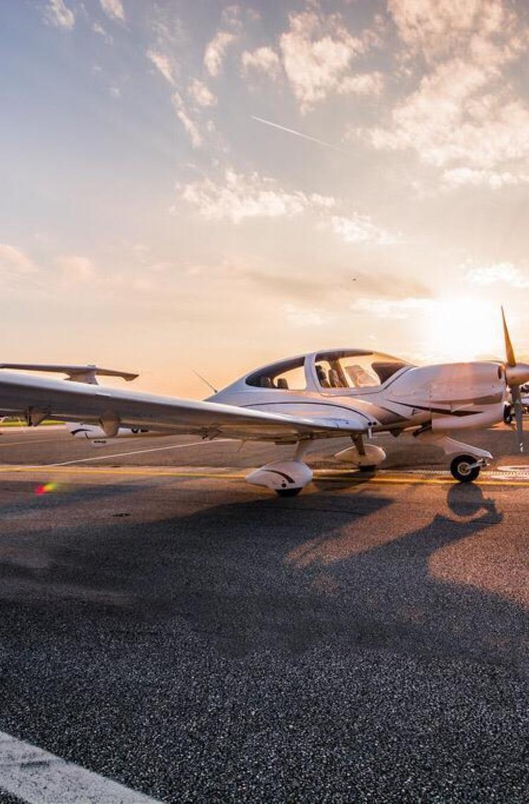 aircraft on a tarmac in front of a sunset